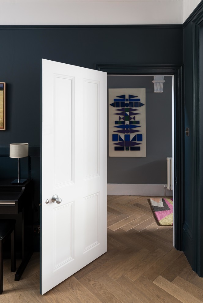 Immagine di un soggiorno design di medie dimensioni con sala formale, pareti blu e parquet chiaro
