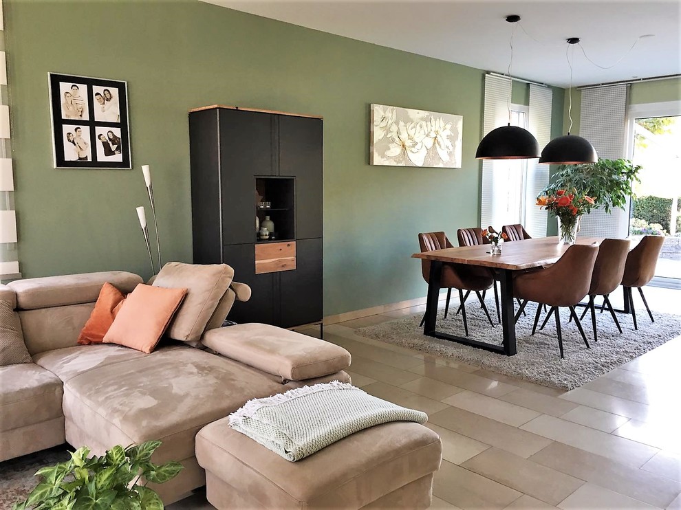 На фото: открытая гостиная комната среднего размера в стиле лофт с зелеными стенами и полом из травертина без камина с