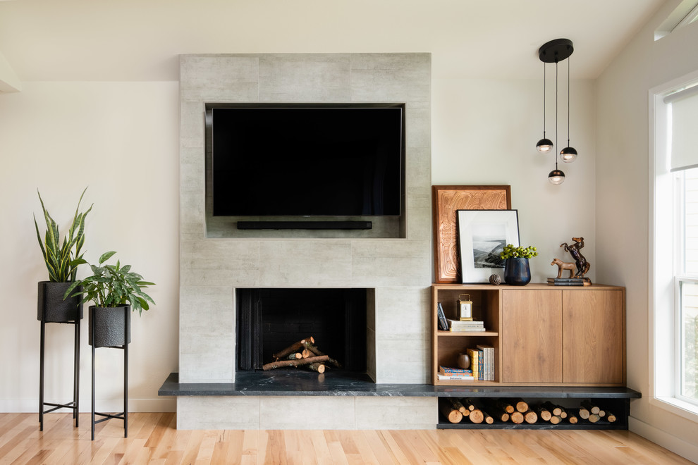 Inspiration for a mid-sized contemporary open concept light wood floor and beige floor living room remodel in Seattle with white walls, a standard fireplace, a wall-mounted tv and a concrete fireplace