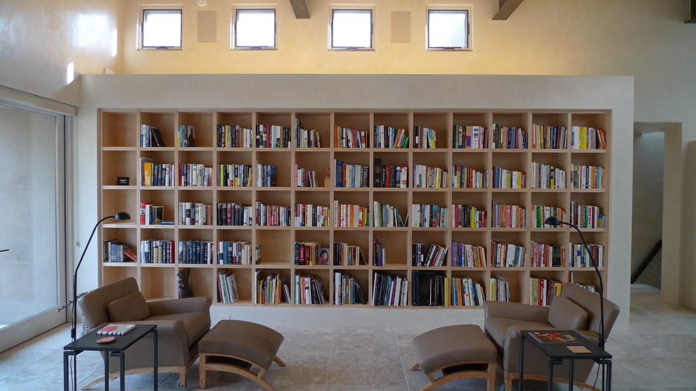 Réalisation d'un grand salon design ouvert avec une bibliothèque ou un coin lecture, un mur beige et sol en béton ciré.