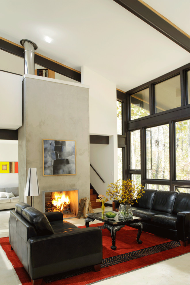 Foto de salón minimalista con marco de chimenea de hormigón y suelo de cemento