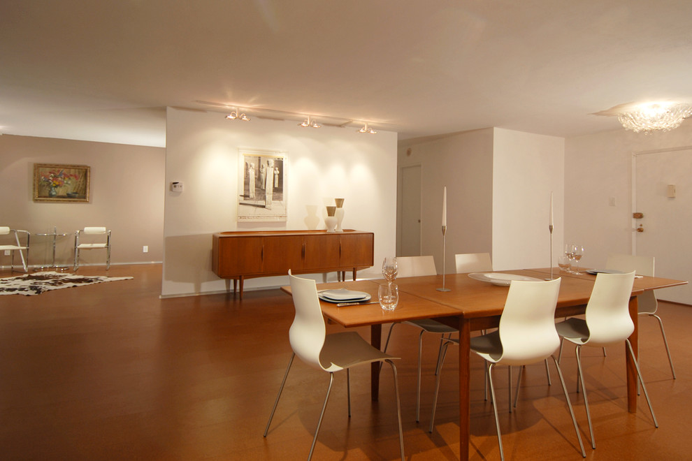 Ejemplo de salón abierto moderno pequeño sin chimenea con paredes blancas, suelo de corcho y suelo marrón