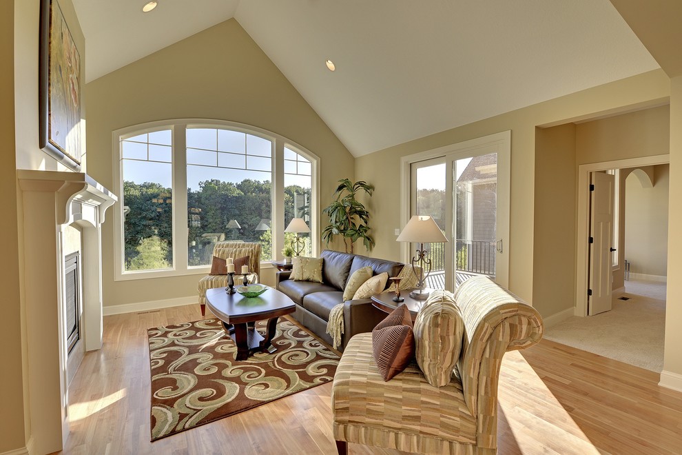 Offenes Klassisches Wohnzimmer mit beiger Wandfarbe, braunem Holzboden, Kamin und gefliester Kaminumrandung in Minneapolis