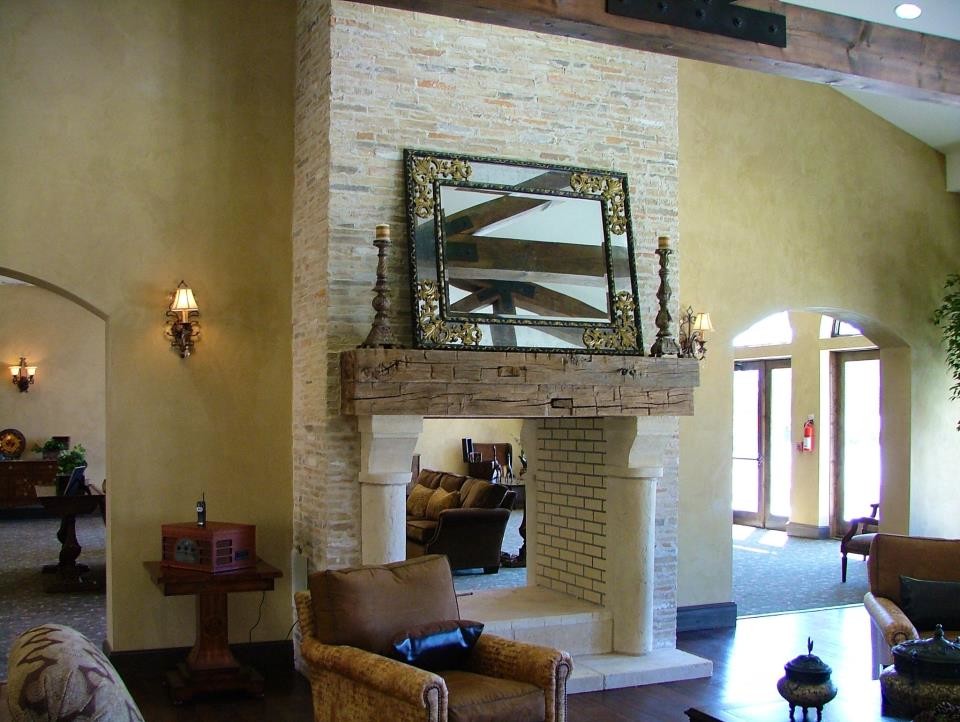 Inspiration for a large rustic formal enclosed living room in Austin with beige walls, dark hardwood flooring, a standard fireplace, a stone fireplace surround and no tv.