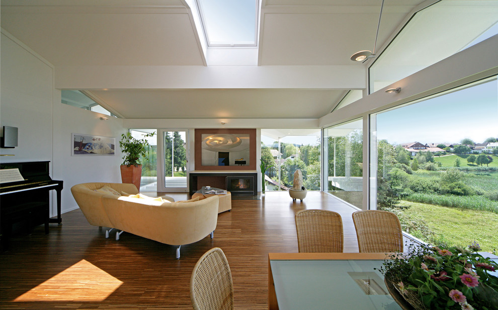 Idee per un grande soggiorno design aperto con pareti bianche, pavimento in legno massello medio e camino classico