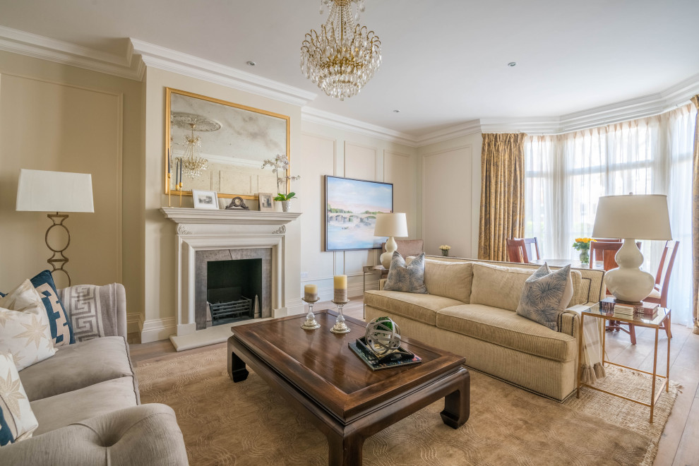 This is an example of a classic living room in Essex with beige walls, medium hardwood flooring, a standard fireplace and brown floors.