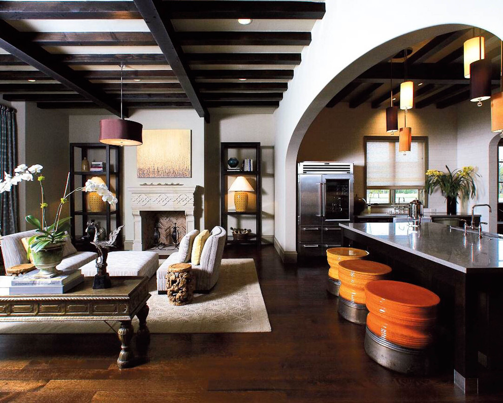 Offenes Mediterranes Wohnzimmer mit dunklem Holzboden und Kamin in Dallas