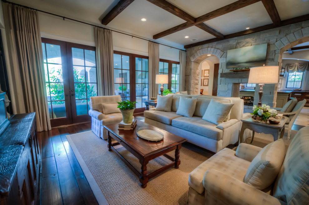 Example of a large classic open concept dark wood floor and brown floor living room design in Houston with white walls, a two-sided fireplace, a stone fireplace and a tv stand