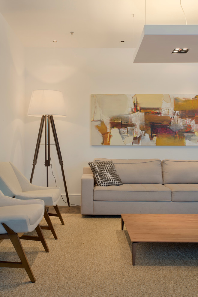 Cette image montre un grand salon minimaliste ouvert avec une salle de réception, un mur blanc et un sol en bois brun.
