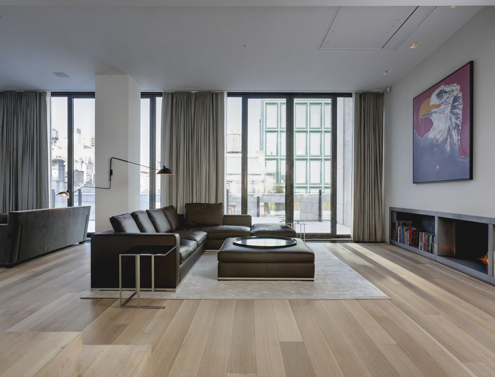 This is an example of a modern living room in New York with a concrete fireplace surround.