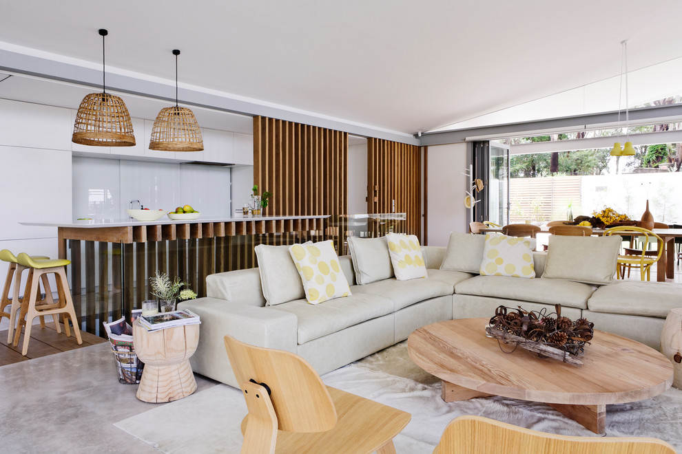 Immagine di un soggiorno design di medie dimensioni e aperto con pareti bianche, pavimento in cemento, TV nascosta e pavimento grigio