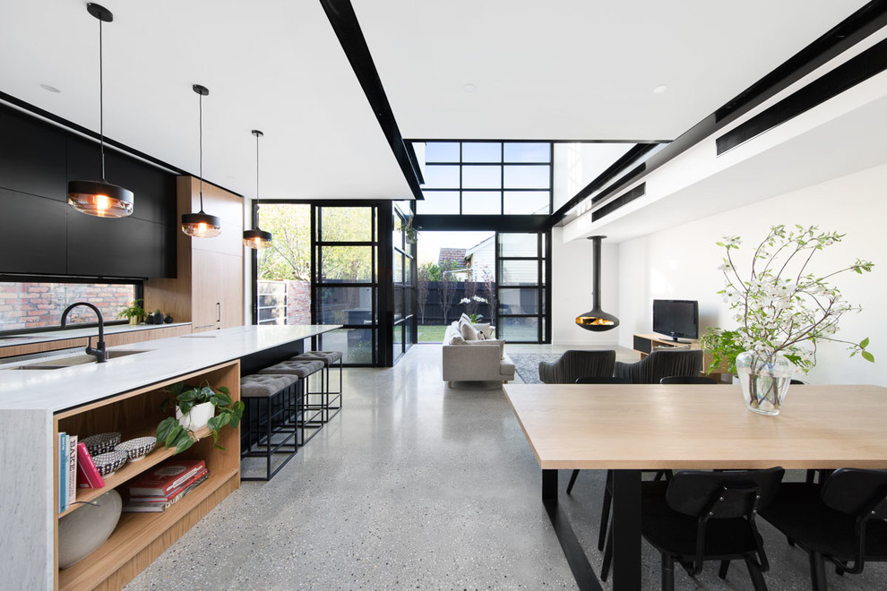 Esempio di un soggiorno minimal di medie dimensioni e stile loft con pareti bianche, pavimento in cemento, camino sospeso e TV autoportante