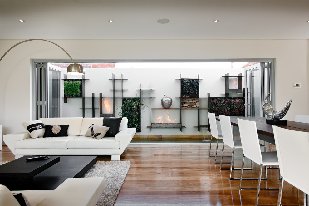 Ispirazione per un soggiorno contemporaneo di medie dimensioni e aperto con pareti bianche e pavimento in legno massello medio