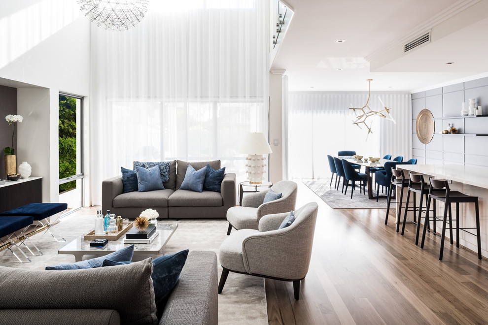 Großes, Offenes Modernes Wohnzimmer ohne Kamin mit weißer Wandfarbe, hellem Holzboden, TV-Wand und braunem Boden in Melbourne