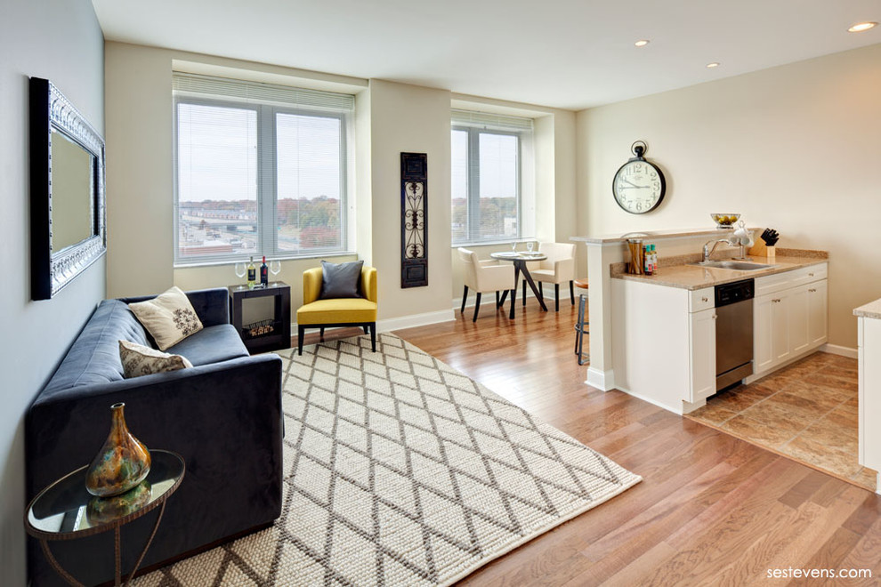 Ejemplo de salón para visitas abierto minimalista con paredes beige y suelo de madera en tonos medios