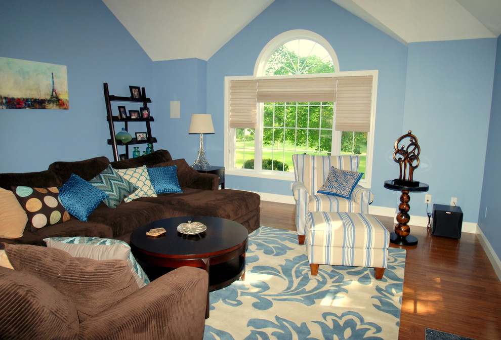 На фото: большая открытая гостиная комната в стиле неоклассика (современная классика) с синими стенами, темным паркетным полом, стандартным камином, фасадом камина из дерева и телевизором на стене