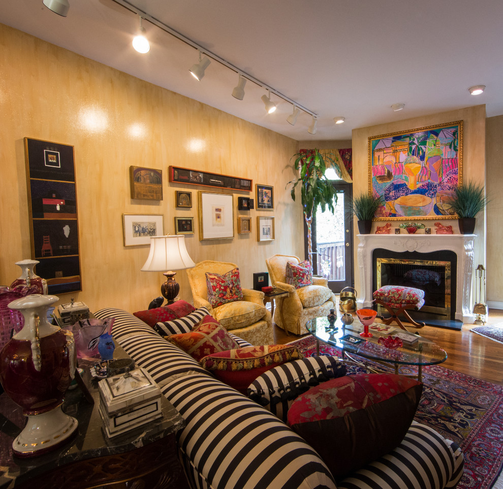 This is an example of a large eclectic enclosed living room in DC Metro with yellow walls, medium hardwood flooring, a standard fireplace and a plastered fireplace surround.