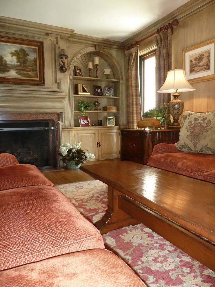 Foto på ett stort vintage separat vardagsrum, med beige väggar, mellanmörkt trägolv, en standard öppen spis, en spiselkrans i trä, ett bibliotek och en dold TV