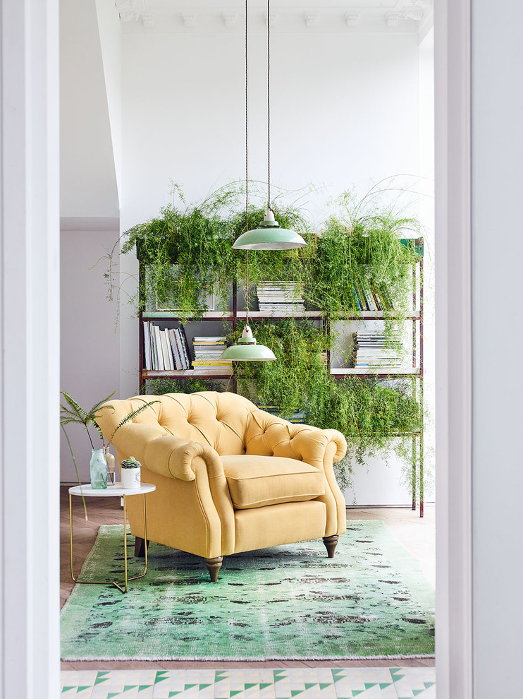 Ispirazione per un piccolo soggiorno chic con libreria, pareti bianche, pavimento in legno massello medio e pavimento marrone