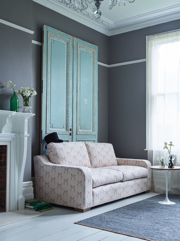 Ispirazione per un piccolo soggiorno classico con pareti grigie, parquet chiaro, cornice del camino in intonaco e pavimento grigio