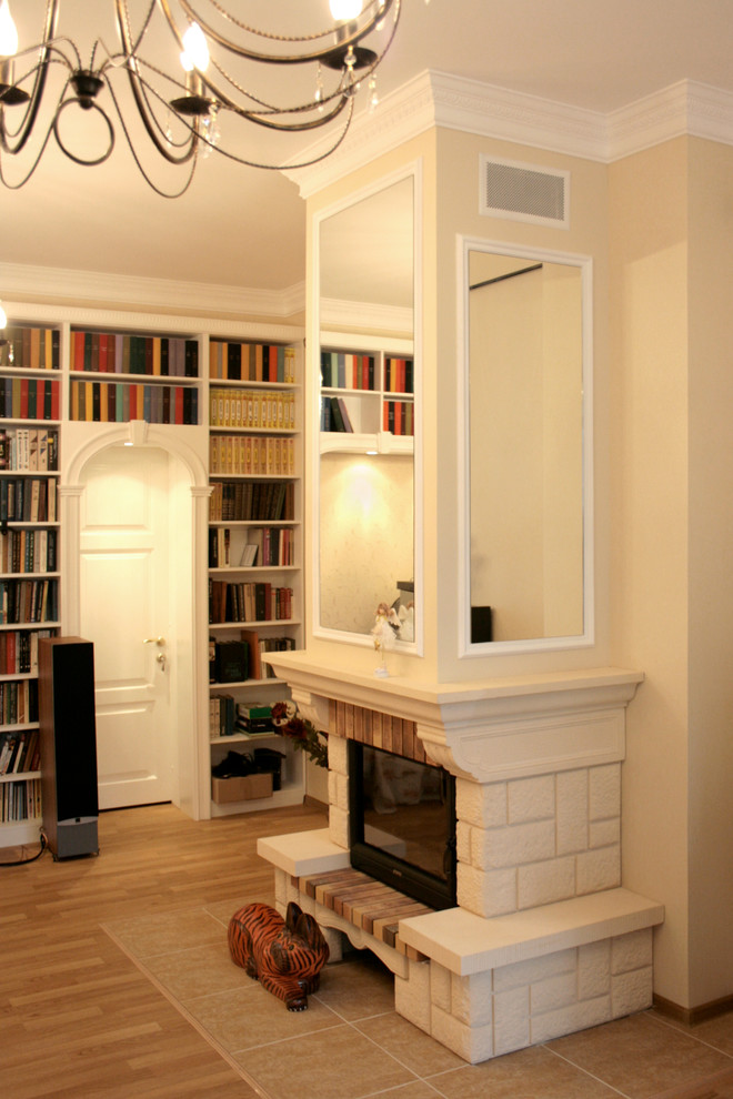 Cette photo montre un salon chic de taille moyenne et fermé avec une bibliothèque ou un coin lecture, un mur beige, parquet clair, une cheminée standard et un manteau de cheminée en pierre.
