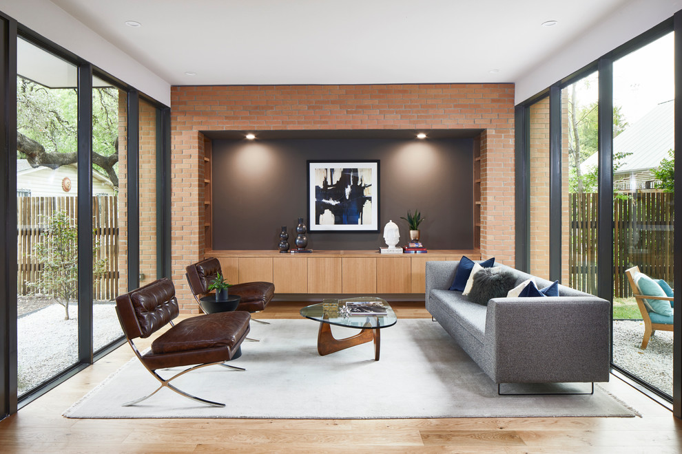 Repräsentatives Modernes Wohnzimmer mit schwarzer Wandfarbe, hellem Holzboden und beigem Boden in Austin