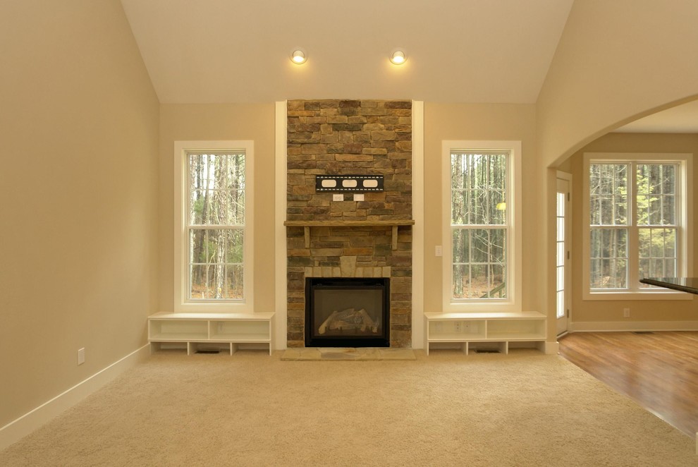 Photo of a medium sized traditional open plan living room in Raleigh with beige walls, carpet, a standard fireplace, a stone fireplace surround and a built-in media unit.