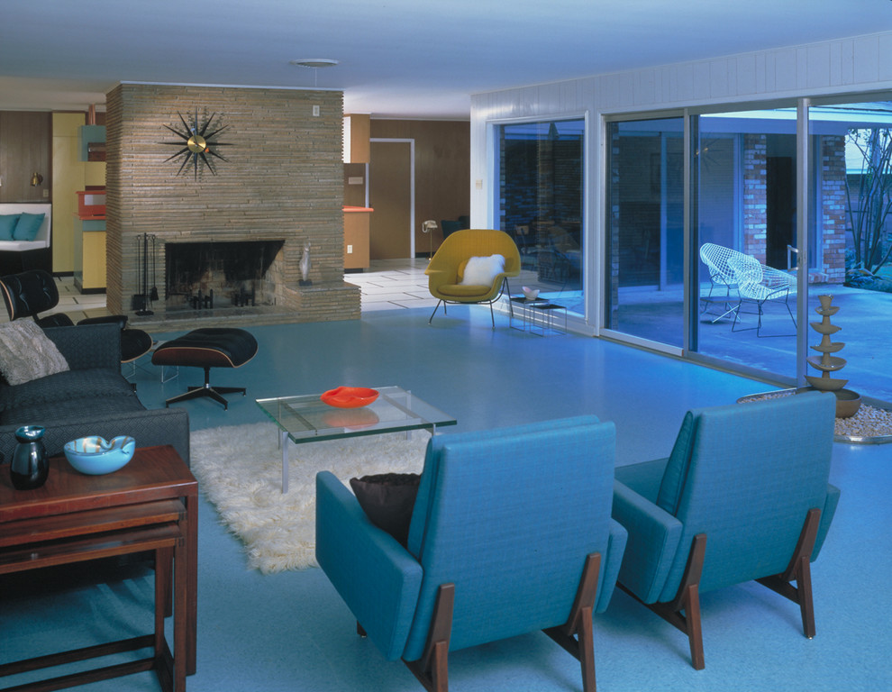 Cette photo montre un salon moderne avec un manteau de cheminée en pierre et un sol bleu.
