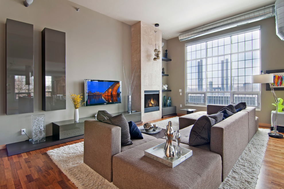 Esempio di un soggiorno aperto con pareti beige, pavimento in legno massello medio, camino classico e TV a parete
