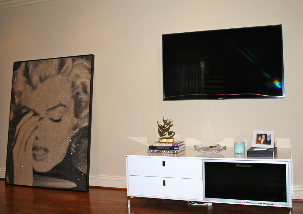 Ejemplo de salón cerrado bohemio grande con paredes beige, suelo de madera oscura y televisor colgado en la pared