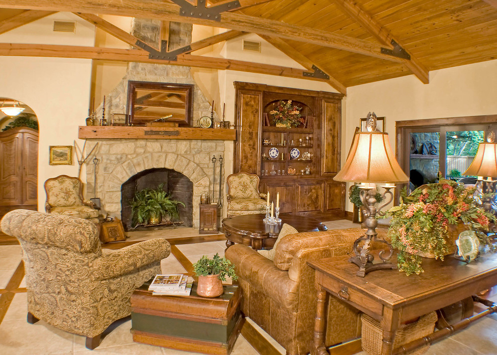 Aménagement d'un salon méditerranéen de taille moyenne et ouvert avec un mur beige, un sol en travertin, une cheminée standard et un manteau de cheminée en pierre.