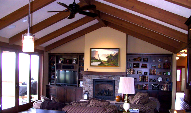 Immagine di un soggiorno stile americano chiuso con pareti beige, pavimento in legno massello medio, camino classico e cornice del camino in pietra