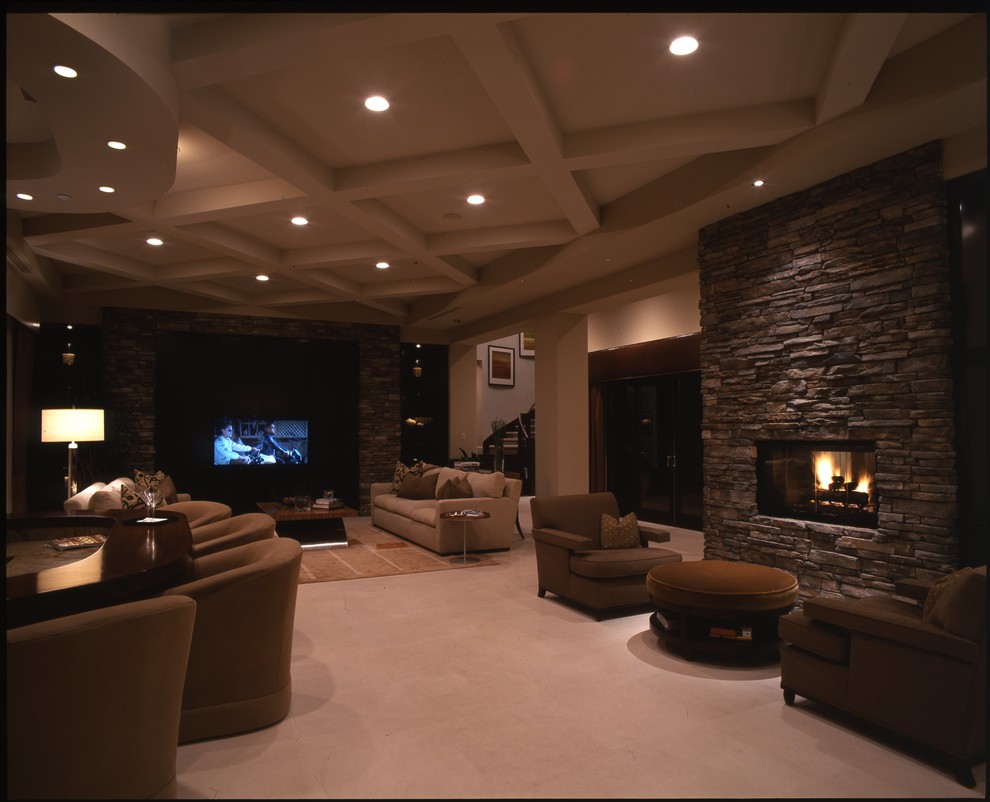 Design ideas for an expansive contemporary formal open plan living room in Las Vegas with brown walls, carpet, a corner fireplace, a stone fireplace surround, a wall mounted tv, beige floors, a vaulted ceiling and brick walls.