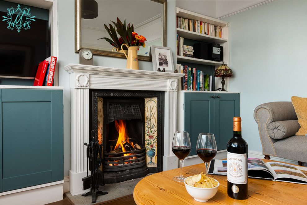 Kleines, Abgetrenntes Klassisches Wohnzimmer mit blauer Wandfarbe, dunklem Holzboden, Kamin, gefliester Kaminumrandung, TV-Wand und braunem Boden in Berkshire