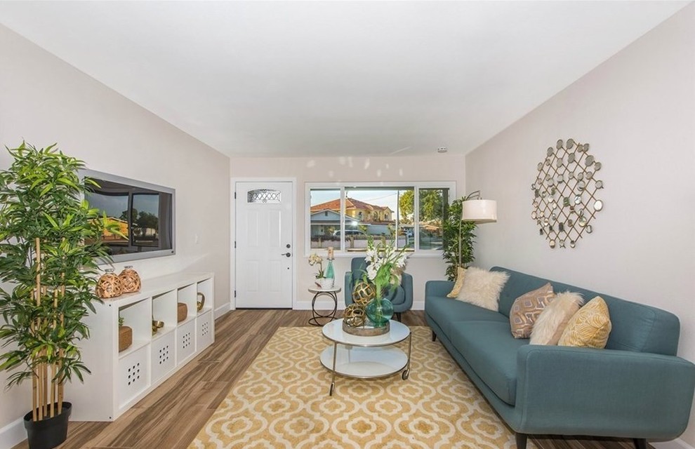 Mittelgroßes, Abgetrenntes Modernes Wohnzimmer mit beiger Wandfarbe, braunem Holzboden, TV-Wand und braunem Boden in Orange County