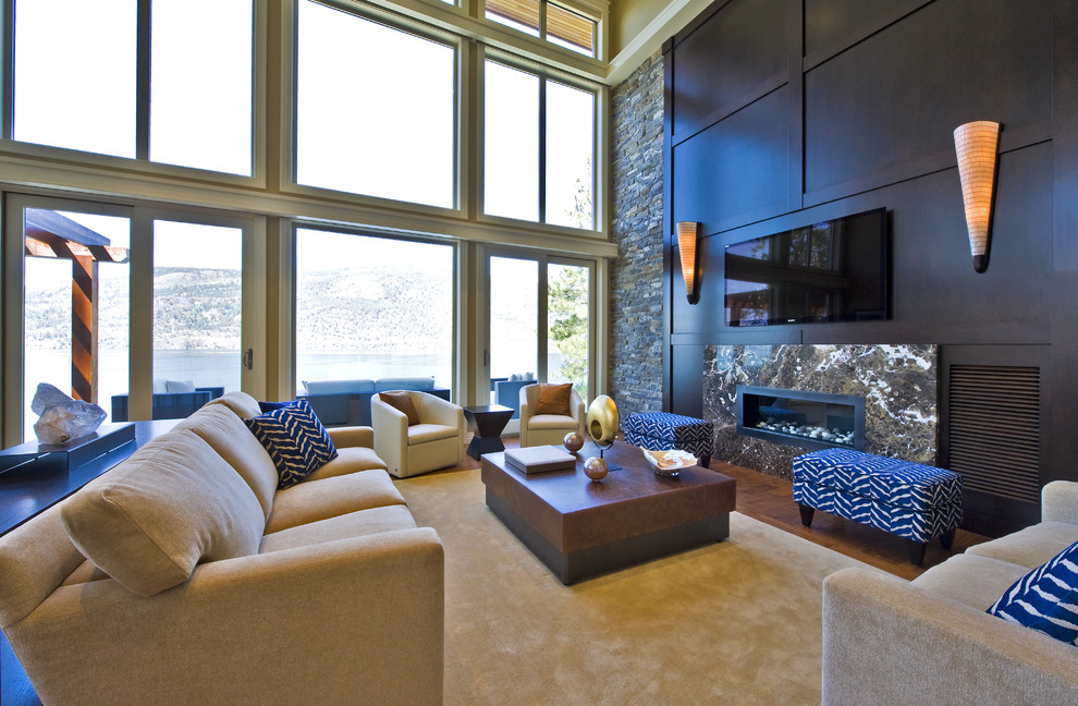 На фото: огромная гостиная комната в современном стиле с телевизором на стене с