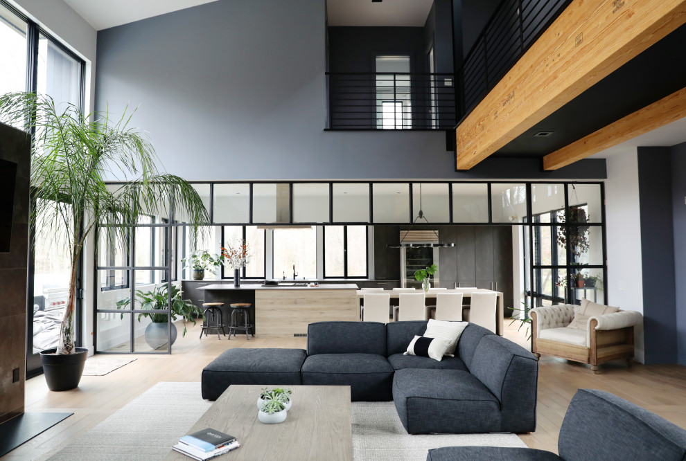 Exempel på ett stort modernt allrum med öppen planlösning, med grå väggar, ljust trägolv, en standard öppen spis, en spiselkrans i trä, en väggmonterad TV och beiget golv
