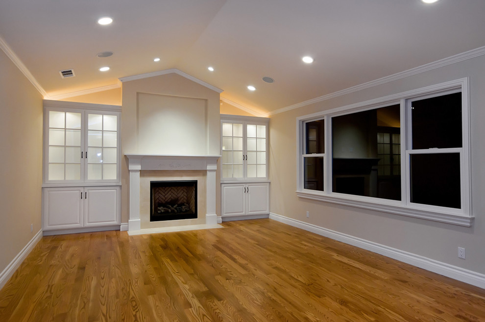 Mid-sized elegant formal and enclosed medium tone wood floor living room photo in San Francisco with gray walls, a standard fireplace, a wood fireplace surround and a media wall