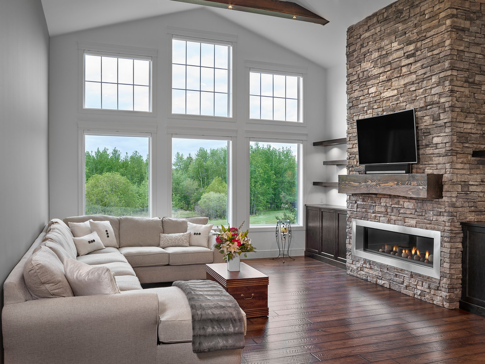 Example of a large arts and crafts formal and open concept medium tone wood floor and brown floor living room design in Other with gray walls, a ribbon fireplace, a stone fireplace and a wall-mounted tv