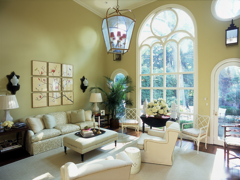 Стильный дизайн: открытая гостиная комната в классическом стиле с желтыми стенами - последний тренд