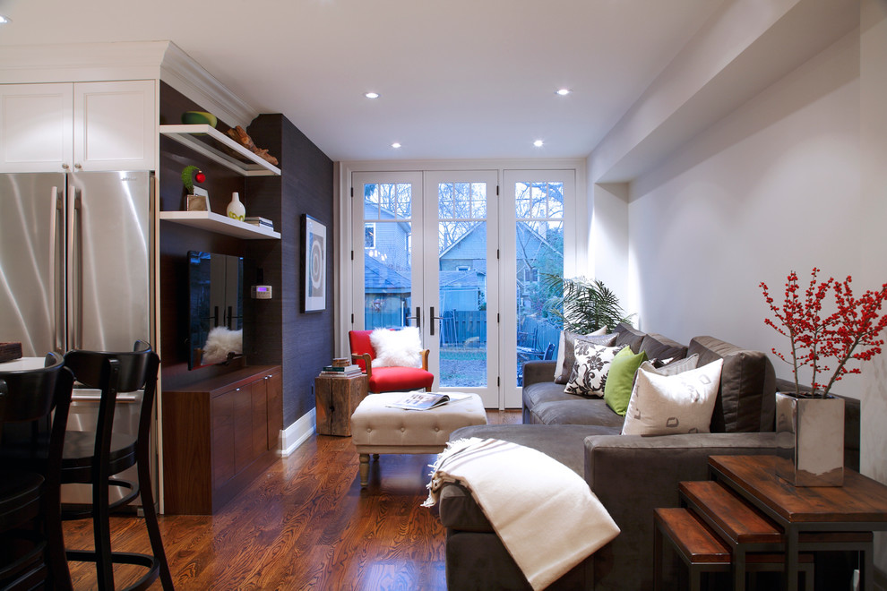 Kleines, Offenes Modernes Wohnzimmer ohne Kamin mit weißer Wandfarbe, braunem Holzboden und TV-Wand in Toronto