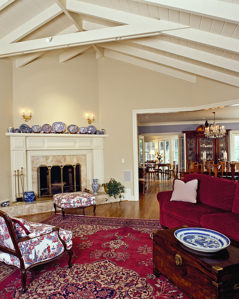 Стильный дизайн: гостиная комната в классическом стиле с бежевыми стенами, угловым камином и ковром на полу - последний тренд
