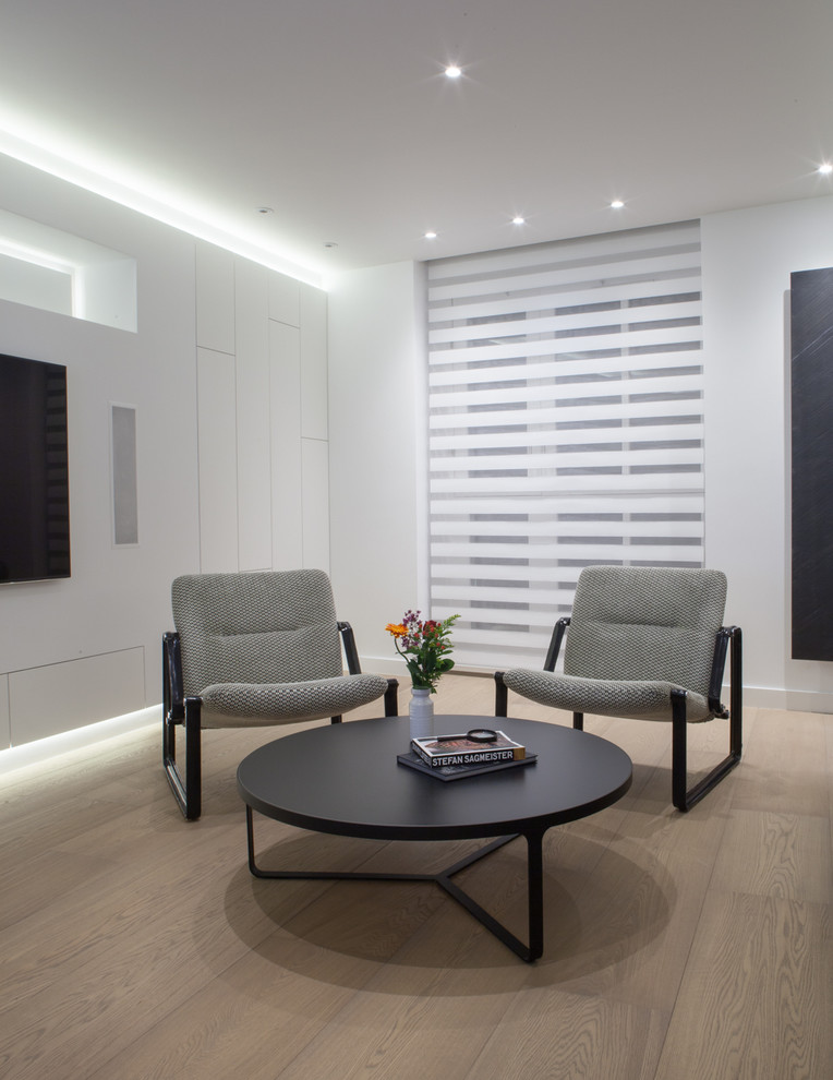 Photo of a large scandi open plan living room in London with a music area, white walls, light hardwood flooring and a wall mounted tv.