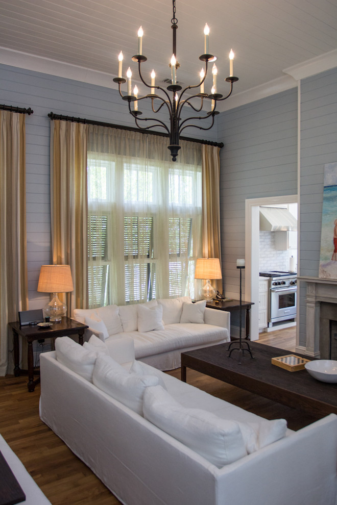 Пример оригинального дизайна: большая гостиная комната в классическом стиле с синими стенами и красивыми шторами