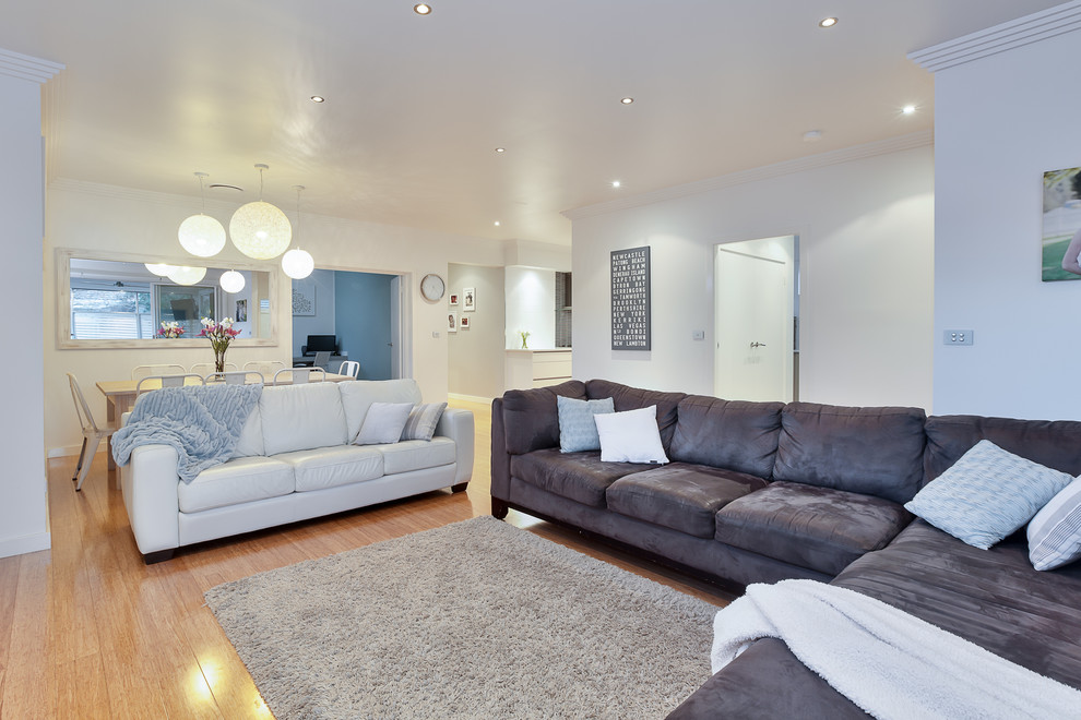 Idee per un soggiorno design di medie dimensioni e aperto con pareti bianche, pavimento beige, parquet chiaro e TV a parete