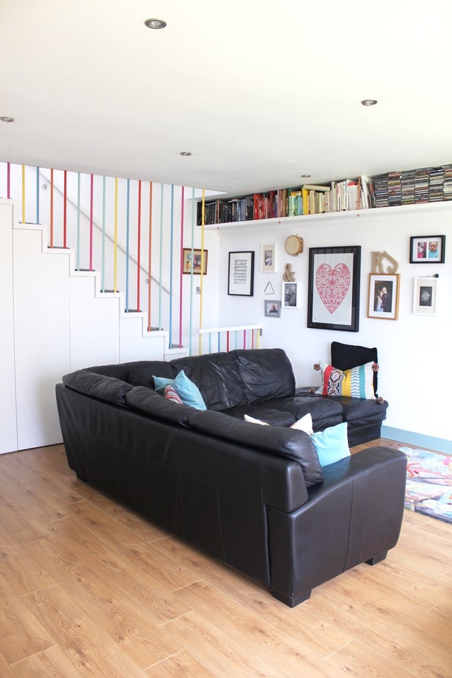 Foto di un soggiorno boho chic di medie dimensioni e aperto con libreria, pareti bianche, parquet chiaro, nessun camino e TV a parete