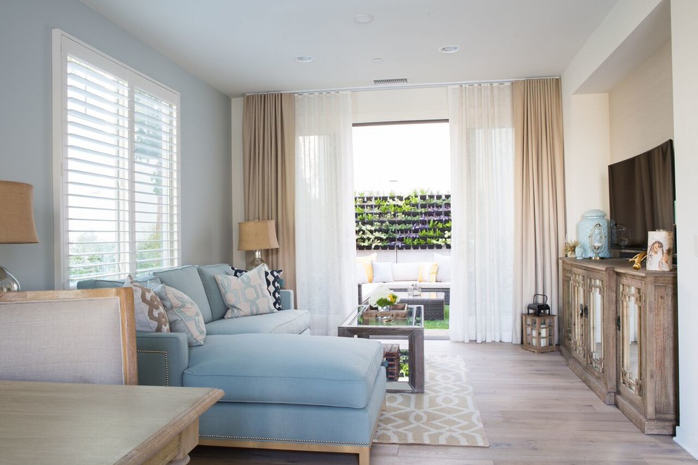 Свежая идея для дизайна: маленькая открытая гостиная комната в стиле неоклассика (современная классика) с синими стенами, светлым паркетным полом и телевизором на стене для на участке и в саду - отличное фото интерьера
