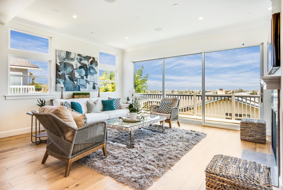 Mid-sized beach style open concept light wood floor living room photo in Los Angeles with white walls, a standard fireplace, a stone fireplace and a wall-mounted tv