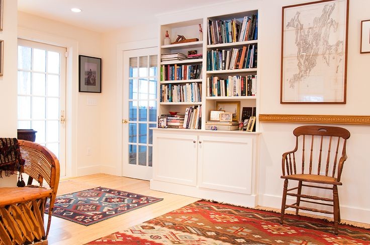 Imagen de biblioteca en casa abierta tradicional de tamaño medio sin chimenea y televisor con paredes beige, suelo de madera clara y suelo beige