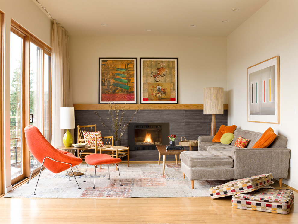 Fernseherloses, Offenes Retro Wohnzimmer mit hellem Holzboden, gefliester Kaminumrandung, Kamin und beiger Wandfarbe in Seattle